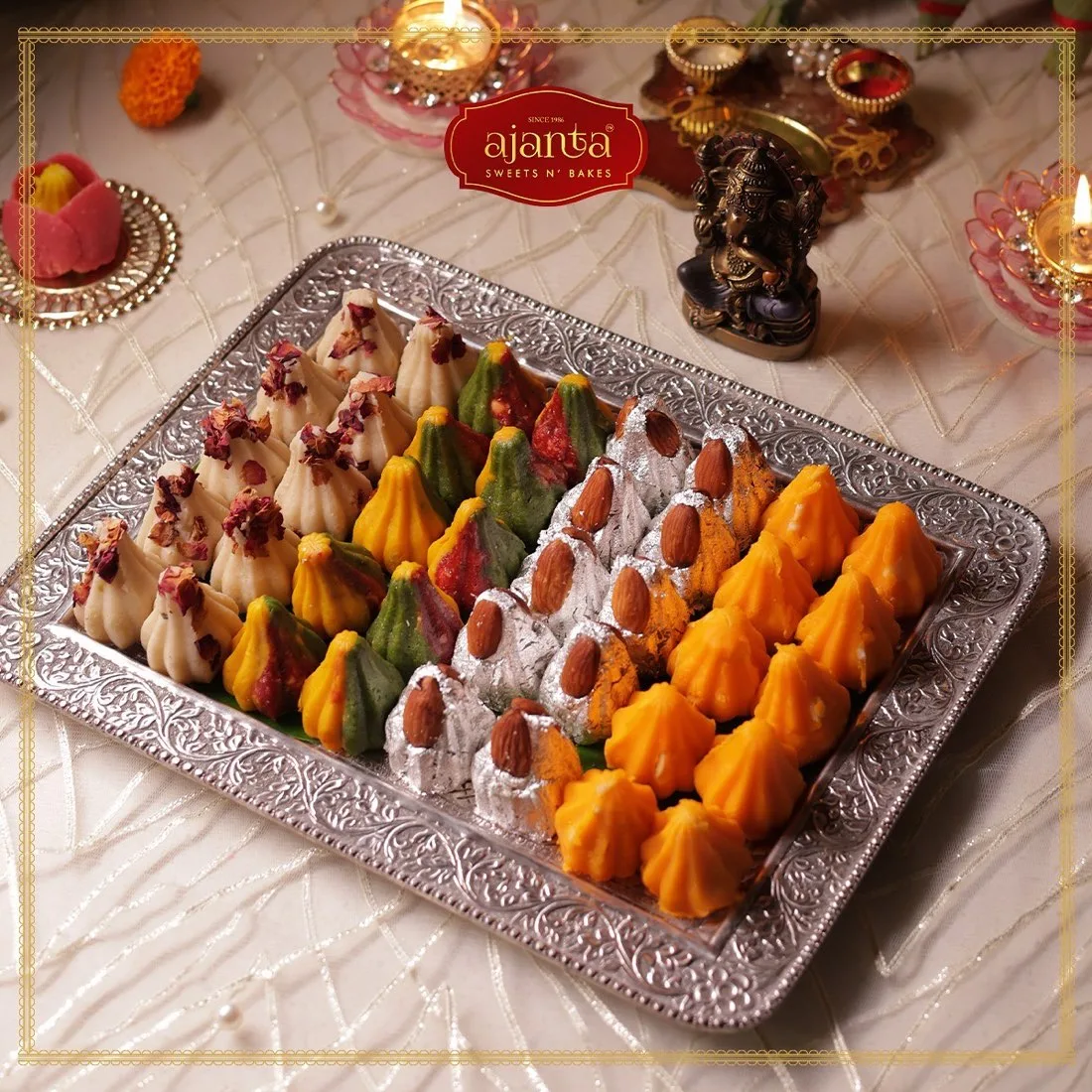 Ajanta colourful modaks on silver tray with logo